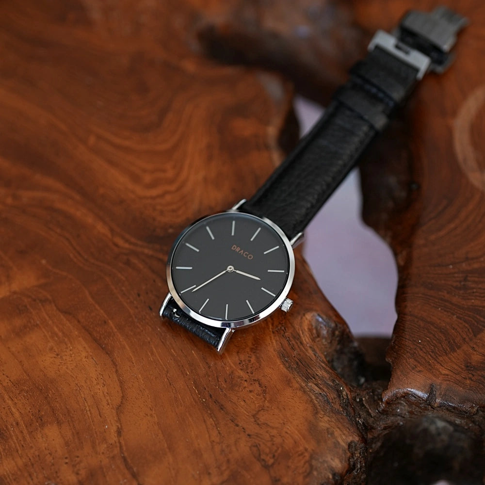 ceas barbati negru cu curea de piele si mecanism quartz pozat pe masa de lemn